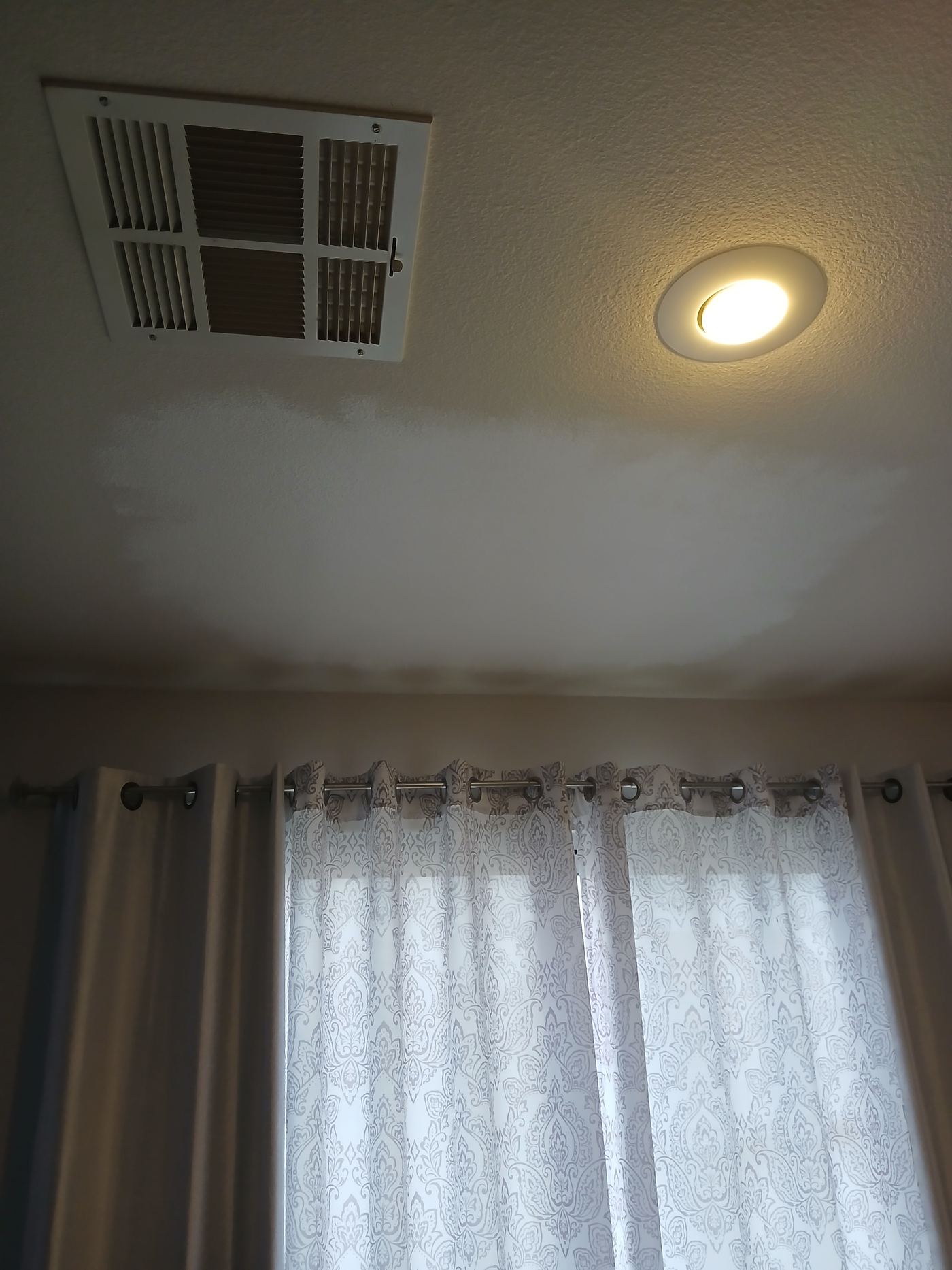 Touch-up paint spot on a wall next to a window and vent, by Wall Repair Pros in Las Vegas
